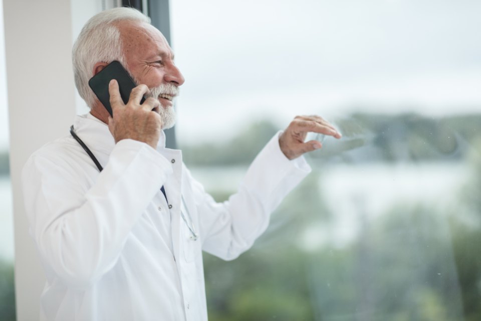 A man in a suit on a phone call by a window
