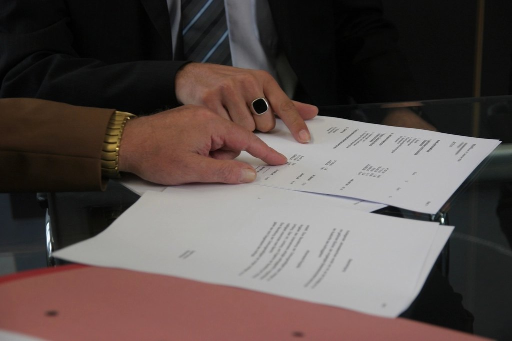 Two people shaking hands across a table